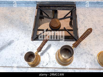 Luogo di cottura del caffè arabo - fuoco, caffettiere - jezva, cezve, ibrido. Jordan. Macchina per il caffè Ibric, vista dall'alto Foto Stock