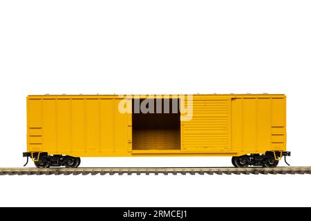 Una carrozza ferroviaria gialla con porta aperta sul tacco della ferrovia. Foto Stock