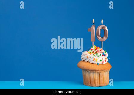 Cupcake di compleanno su sfondo blu - numero di candela di compleanno rosa Foto Stock