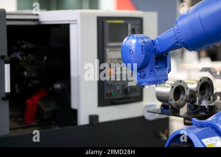 Robot e tornio CNC. Cella di lavoro robotica automatizzata. Messa a fuoco selettiva. Foto Stock