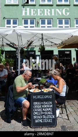 Turista che si gode il tradizionale Smørrebrød danese nei ristoranti di Nyhavn, Copenaghen, Danimarca. Foto Stock