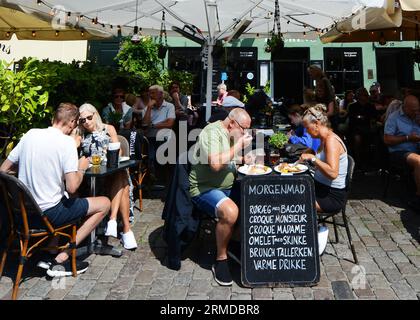 Turista che si gode il tradizionale Smørrebrød danese nei ristoranti di Nyhavn, Copenaghen, Danimarca. Foto Stock