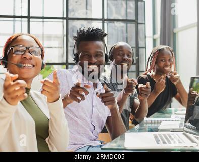 Team afro-americano che lavora presso l'ufficio del call center per aiutare le persone con assistenza per il telemarketing Foto Stock