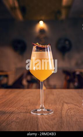 Elegante cocktail giallo eggnog alla frutta della passione sul tavolo da bar Foto Stock