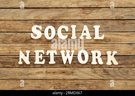 Social network parole in legno su sfondo in legno, vista dall'alto. Foto Stock