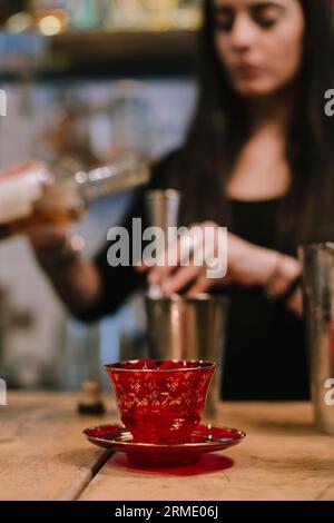 La giovane barwoman prepara un cocktail alcolico al bar Foto Stock