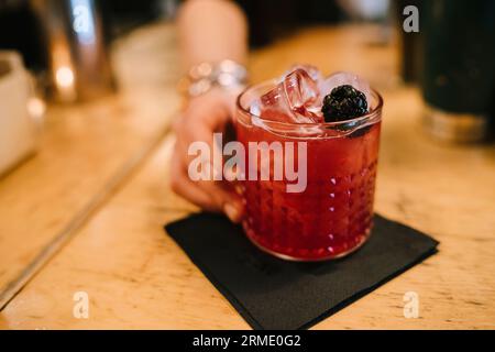 La giovane barwoman prepara un cocktail alcolico al bar Foto Stock