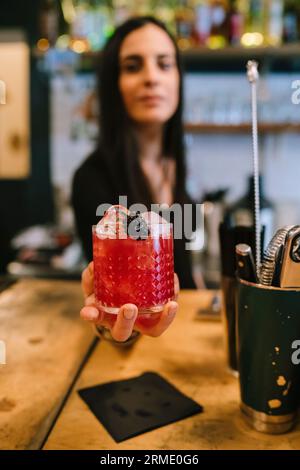 La giovane barwoman prepara un cocktail alcolico al bar Foto Stock