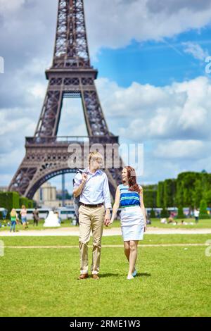 Romantica coppia che cammina a Parigi vicino alla Torre Eiffel Foto Stock