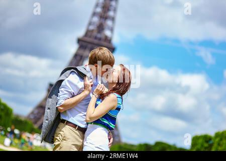 Romantico bacio di coppia a Parigi vicino alla Torre Eiffel Foto Stock