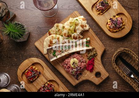 tartare di manzo in marmo su una tavola di legno Foto Stock