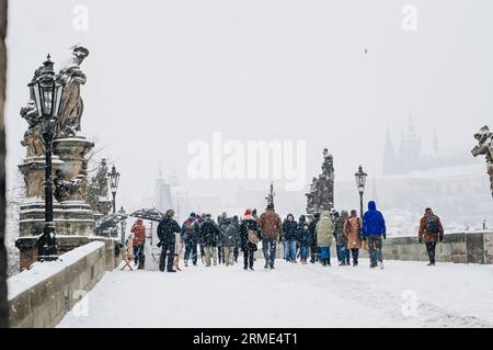 Turisti, passanti e artisti sul ponte nella neve. Foto Stock