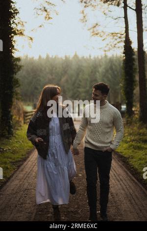 La giovane coppia innamorata ama fare una passeggiata invernale su un sentiero nella foresta Foto Stock