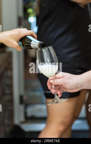 Bicchiere da vino per gli ospiti in fase di ricarica al matrimonio Foto Stock