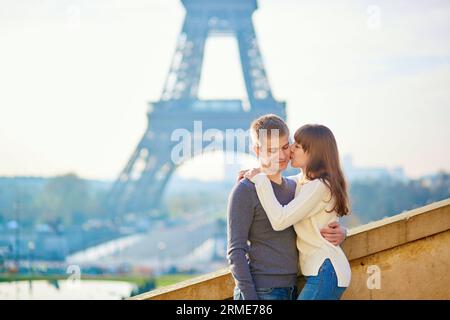 Romantica coppia amorevole a Parigi che si baciava vicino alla Torre Eiffel la mattina presto Foto Stock