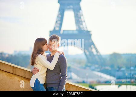 Romantica coppia amorevole a Parigi che si baciava vicino alla Torre Eiffel la mattina presto Foto Stock