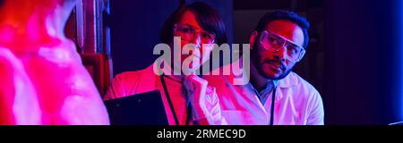 scienziati multietnici che guardano alieni umanoidi nel centro dell'innovazione, concetto futuristico, banner Foto Stock