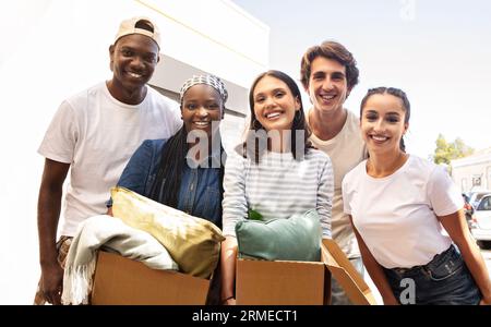 Gruppo multiculturale di studenti in possesso di scatole di carta con oggetti personali Foto Stock
