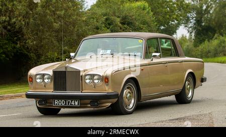 Whittlebury, Northants, Regno Unito - 26 agosto 2023: 1980 auto Rolls Royce Silver Shadow II Bronze che viaggia su una strada di campagna inglese Foto Stock