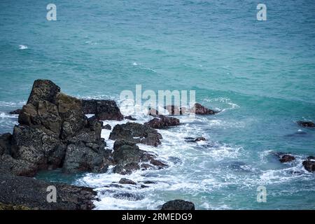 Le grandi pietre disseminate lungo la spiaggia erose dalle onde del mare. Foto Stock