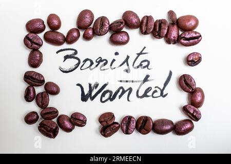 Il barista voleva essere scritto con vernice nera su carta bianca in una cornice rosa con chicchi di caffè, cartello di reclutamento Foto Stock