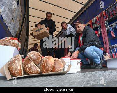 28 agosto 2023, Assia, Gräfenhausen: Il cibo donato viene distribuito ai camionisti. Per quasi sei settimane, i conducenti di un'azienda di trasporti polacca dell'Uzbekistan, della Georgia e di altri paesi dell'Europa orientale e dell'Asia centrale hanno scioperato nell'area di servizio dell'Assia meridionale. Gli uomini chiedono salari eccezionali. (Al dpa "parlamentare europeo per i conducenti in sciopero: Sono necessari più controlli") foto: Arne Dedert/dpa Foto Stock