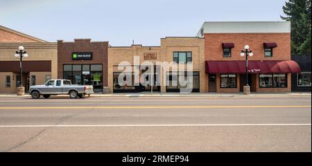 Conrad, Montana, USA – 17 agosto 2023: Edifici in mattoni e pick-up su Main Street Foto Stock
