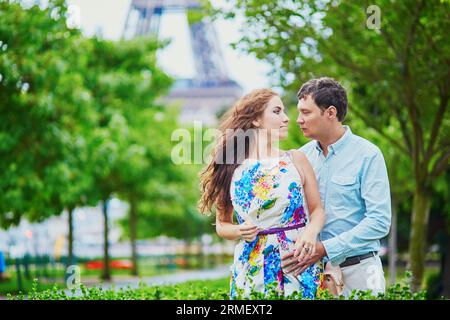 Coppia romantica e amorevole che ha un appuntamento vicino alla Torre Eiffel. Turisti in vacanza o durante la loro luna di miele a Parigi, in Francia Foto Stock