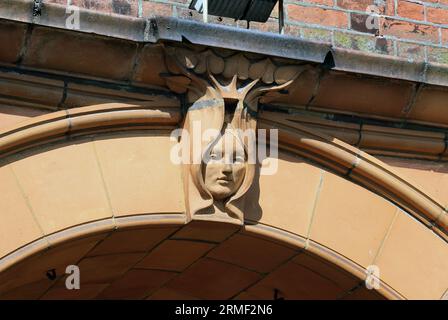 Primo piano della facciata del grande Ippodromo di Yarmouth che mostra una chiave di volta ad arco a forma di testa art nouveau incorniciata da foglie. Foto Stock