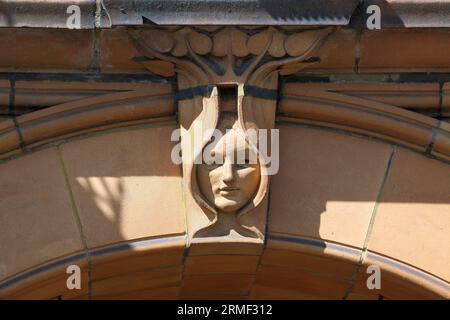 Primo piano della facciata del grande Ippodromo di Yarmouth che mostra una chiave di volta ad arco a forma di testa art nouveau incorniciata da foglie. Foto Stock