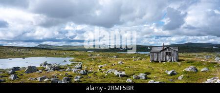 vecchio fienile e rocce sulla pianura di hardangervidda in norvegia Foto Stock