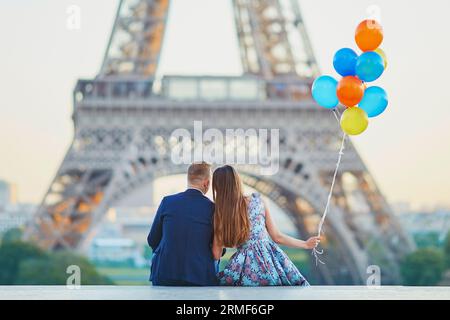 Coppia amorevole con un sacco di palloncini colorati che si baciano vicino alla Torre Eiffel a Parigi, in Francia Foto Stock