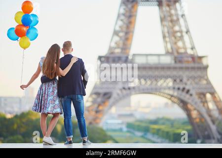 Coppia amorevole con un sacco di palloncini colorati che si baciano vicino alla Torre Eiffel a Parigi, in Francia Foto Stock