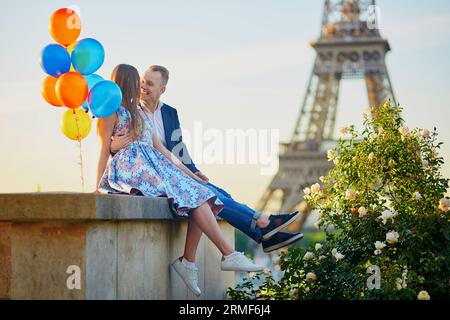 Coppia romantica con palloncini colorati vicino alla Torre Eiffel a Parigi, Francia Foto Stock