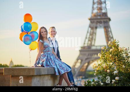 Coppia amorevole con un sacco di palloncini colorati che si baciano vicino alla Torre Eiffel a Parigi, in Francia Foto Stock