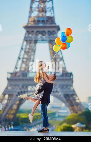 Coppia romantica con palloncini colorati vicino alla Torre Eiffel a Parigi, Francia Foto Stock