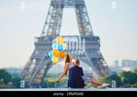 Coppia amorevole con un sacco di palloncini colorati che si baciano vicino alla Torre Eiffel a Parigi, in Francia Foto Stock