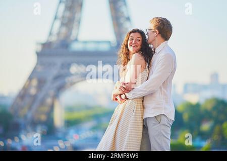 Felice coppia romantica a Parigi, vicino alla Torre Eiffel. Turisti che trascorrono le loro vacanze in Francia Foto Stock