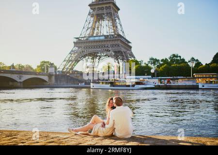 Felice coppia romantica a Parigi, vicino alla Torre Eiffel. Turisti che trascorrono le loro vacanze in Francia Foto Stock