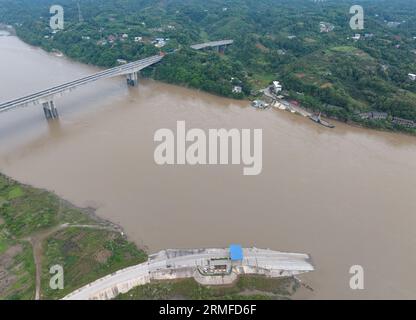 (230828) -- YIBIN, 28 agosto 2023 (Xinhua) -- questa foto aerea scattata il 28 agosto 2023 mostra un traghetto e il grande ponte di Nixi Minjiang nel distretto di Xuzhou di Yibin, nella provincia del Sichuan della Cina sud-occidentale. Il servizio di traghetto attraverso il fiume che collega la città di Nixi e la città di Juexi nel distretto di Xuzhou di Yibin è iniziato nel maggio 1992. Questo servizio di traghetto e' stato uno dei piu' importanti metodi di trasporto per le persone locali che vivono nelle vicinanze su entrambi i lati del fiume Minjiang. Dato che il grande ponte di Nixi Minjiang ha aperto al traffico qui il Lunedi', anche il servizio di traghetto vecchio di 31 anni e' terminato lo stesso giorno. La Foto Stock