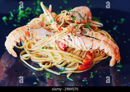 Deliziosa pasta con aragoste, verdure e salsa servita nel ristorante italiano Foto Stock
