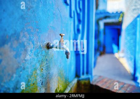 Piccola fontana con acqua potabile in una strada a Medina di Chefchaouen, in Marocco, piccola cittadina nel nord-ovest del Marocco nota per i suoi edifici blu Foto Stock
