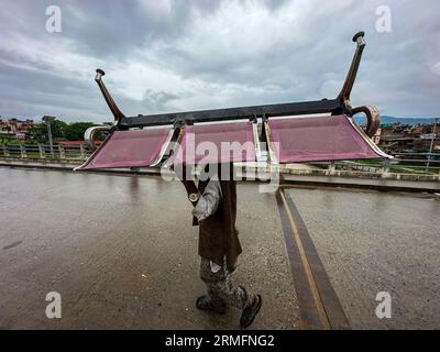 Kathmandu, Bagmati, Nepal. 28 agosto 2023. Un uomo che porta una sedia di ferro sulla testa cammina per la strada di Kathmandu, Nepal, il 28 agosto 2023. (Immagine di credito: © Sunil Sharma/ZUMA Press Wire) SOLO USO EDITORIALE! Non per USO commerciale! Foto Stock