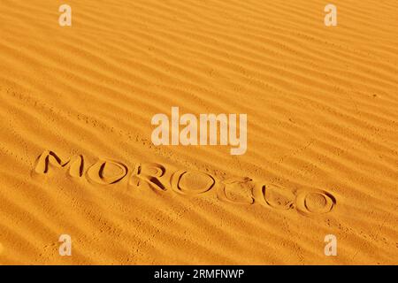 Parola Marocco scritta sulla sabbia nelle dune di sabbia del deserto del Sahara, Merzouga, Marocco Foto Stock