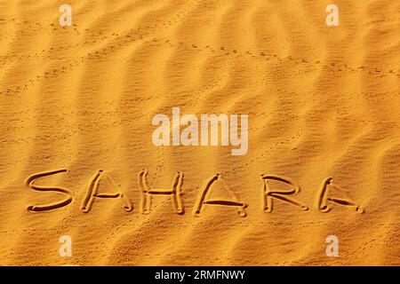 Parola Sahara scritta sulla sabbia nelle dune di sabbia del deserto del Sahara, Merzouga, Marocco Foto Stock