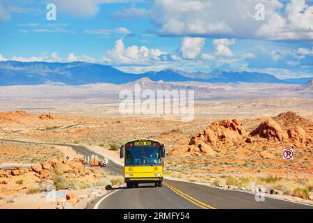 Guida di uno scuolabus su una strada tortuosa nel parco nazionale Valley of the Fire in Nevada, Stati Uniti Foto Stock