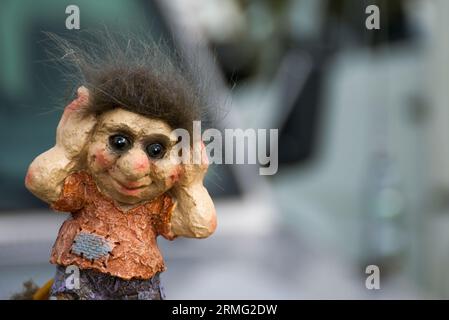 Un piccolo troll norvegese che gli copre le orecchie. I troll sono creature famose nel mito scandinavo. Immagine molto dettagliata con il copyspace. Foto Stock