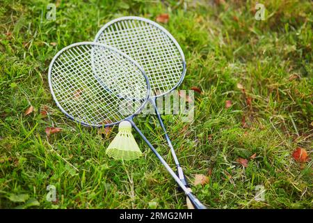Volano e due racchette da badminton su erba verde Foto Stock