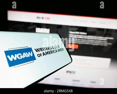 Smartphone con il logo del sindacato Writers Guild of America West (WGAW) sullo schermo davanti al sito Web. Concentrarsi sul centro del display del telefono. Foto Stock