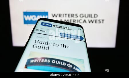 Telefono cellulare con sito Web della Labour union Writers Guild of America West (WGAW) sullo schermo davanti al logo. Mettere a fuoco in alto a sinistra sul display del telefono. Foto Stock